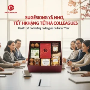 Một hộp quà Tết lớn chứa nhiều món healthy đặt giữa bàn làm việc có nhiều đồng nghiệp xung quanh.